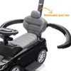 Close-up of a black ride-on car with a gray seat and steering wheel, highlighting a removable push bar. Produktbild-Vorschau