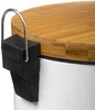 Close-up of the lid and side of a white trash can with a bamboo lid and a black clip mechanism. Anteprima dell’immagine prodotto