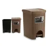 Three trash cans are displayed against a white background. Two are brown and one is black. The brown cans have a woven texture and a pedal. The larger brown can has a label with the word "Elegance" on it. Anteprima dell’immagine prodotto