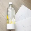 A Wessper S1 SodaMaker bottle with lemon slices and papers with drawings on a wooden table. Voir les images du produit