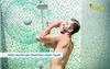 A man is singing and holding a pink object in his mouth while taking a shower. A white speaker with a green light is mounted on the shower wall. Voir les images du produit