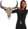 A woman is holding a decorative bull skull with intricate carvings. Podgląd zdjęcia produktu