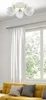 A ceiling light fixture above a yellow sofa and next to a window with white curtains. Náhled obrázku produktu