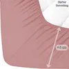 A close-up view of a pink fitted sheet, showing the elasticized edge and a measurement indicator. Produktbild-Vorschau