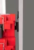 A close-up side view of red plastic connectors attached to a white vertical surface. Produktbild-Vorschau