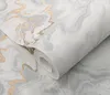 A close-up of a roll of wallpaper with a marble pattern and gold glitter accents. Produktbild-Vorschau