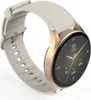 A smartwatch with a gold-colored case and a white strap is shown from a diagonal angle against a white background. Voir les images du produit