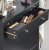 A close-up view of an open drawer in a black dresser, revealing brushes and other items. Náhľad obrázku produktu