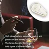 A person smoking a cigar and holding a glass of whiskey, with an ashtray in the foreground. Produktbild-Vorschau