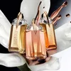 Three bottles of Thierry Mugler Alien Goddess Supra Florale perfume are displayed in a studio setting with abstract floral elements and liquid splashes. Produktbild-Vorschau