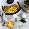 An air fryer filled with french fries, with a small basket of fries and a bowl of salt next to it. Podgląd zdjęcia produktu