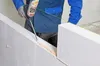 A person is applying construction adhesive foam to a wall made of white blocks. Produktbild-Vorschau