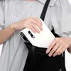 A person is placing a white projector into a black tote bag. Voir les images du produit