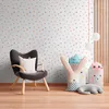 A child's room with a polka dot wallpaper, a chair, and stuffed animals. Produktbild-Vorschau