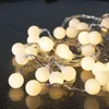 A close-up shot of a string of white LED lights with a reflective dark surface. Náhled obrázku produktu