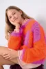 A young girl wearing a colorful sweater. Produktbild-Vorschau
