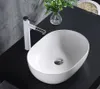 A white oval countertop sink with a white faucet on a black countertop. Anteprima dell’immagine prodotto