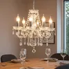 A crystal chandelier hangs above a dining table set with wine glasses. Anteprima dell’immagine prodotto