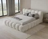 A bedroom with a large, plush bed and large windows overlooking a green landscape. Voir les images du produit