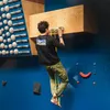 Ein Kletterer trainiert an einem VerticalBoard FIRST von YY Vertical; umgeben von Klettergriffen in einer Kletterhalle. Náhľad obrázku produktu