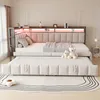 A bedroom scene featuring a beige upholstered daybed with a pull-out trundle bed, decorated with teddy bears and a blanket. Voir les images du produit