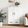 A white highboard with black handles and legs, placed in a room with a plant and a sofa. Voir les images du produit