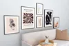 A collection of framed art prints displayed on a wall above a sofa. Produktbild-Vorschau