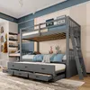 A grey bunk bed with a pull-out trundle bed and drawers, set up in a child's bedroom. Voir les images du produit