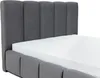 A close-up view of a bed with a mattress and a grey upholstered headboard and frame. Náhled obrázku produktu