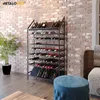 A wine rack filled with wine bottles in a room with a brick wall, a plant, and furniture. Náhľad obrázku produktu
