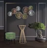 A modern living room setting with decorative wall art, a green stool, a gold accent table, and a bonsai tree. Produktbild-Vorschau