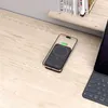 A black MagSafe power bank is placed on a wooden desk next to a laptop. Voir les images du produit