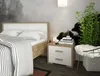 A bedroom scene with a bed, nightstand, and plant. Náhled obrázku produktu
