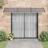 A vidaXL door canopy is installed above a sliding glass door on a brick wall. Náhled obrázku produktu