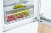 A close-up view of the inside of a refrigerator, showing a drawer filled with lettuce and peaches. Produktbild-Vorschau