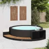 An outdoor patio scene with a whirlpool and surrounding deck, featuring decorative wall art and greenery. Produktbild-Vorschau