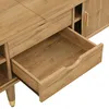 A close-up view of an open drawer on a wooden TV stand with gold accents. Produktbild-Vorschau