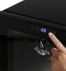 A close-up view of a finger interacting with the digital display of a black appliance, possibly a wine cooler. Produktbild-Vorschau