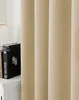 A close-up view of a beige curtain with a book on a white surface to the left. Produktbild-Vorschau