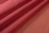A close-up shot of folded red fabric, likely curtains, with soft lighting. Produktbild-Vorschau