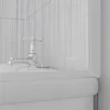 A close-up view of a bathtub faucet and the edge of a bathtub. Anteprima dell’immagine prodotto