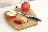 An apple and its slices on a wooden cutting board with a knife. Podgląd zdjęcia produktu