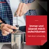 A person is using a manual milk frother. Produktbild-Vorschau