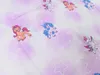 A close-up view of a fabric with a pattern of cartoon ponies and stars. Náhled obrázku produktu