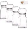 Four clear glass spice jars with silver lids are arranged in a row on a white background. A small box with product information is in the upper right corner. Náhled obrázku produktu