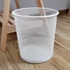 A white mesh waste bin sits on a wooden floor next to a wooden stand. Produktbild-Vorschau