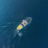 A person is paddleboarding on a blue body of water. Náhled obrázku produktu