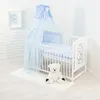 A baby crib with bedding, a canopy, and a teddy bear. Voir les images du produit