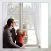 A mother and child looking out a window at a snowy scene. Podgląd zdjęcia produktu