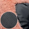 A close-up view of the underside of a pink plush dog bed, showing the anti-slip nubs on the black fabric base. Anteprima dell’immagine prodotto
